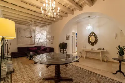 a living room with a table and a couch at NUEVO-NEW Casa Palacio M anuela in Jerez de la Frontera