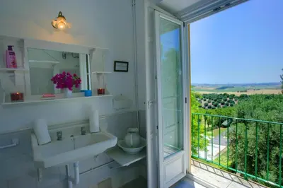 a bathroom with a sink and a balcony with a view at Hacienda La Parrilla Alta in Arcos de la Frontera