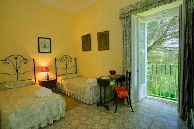 a bedroom with two beds and a desk with a window at Hacienda La Parrilla Alta in Arcos de la Frontera