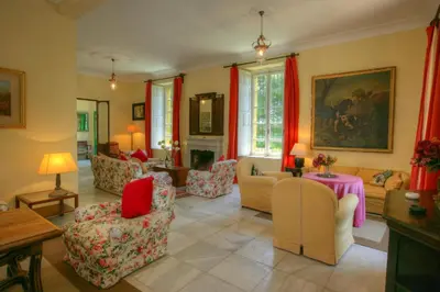 a living room with red curtains and a couch and chairs at Hacienda La Parrilla Alta in Arcos de la Frontera