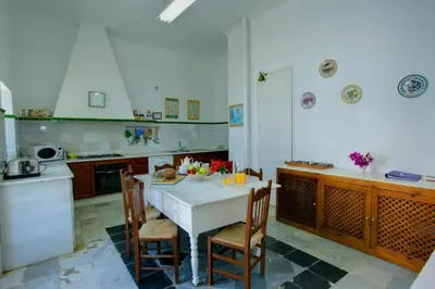 a kitchen with a white table and chairs in it at Hacienda La Parrilla Alta in Arcos de la Frontera