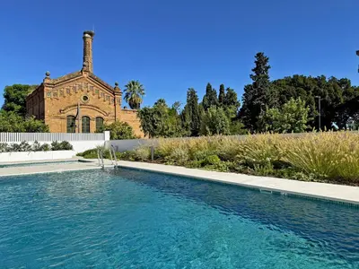 a swimming pool in a garden next to a building at La Solera de Jerez - Ole Solutions in Jerez de la Frontera