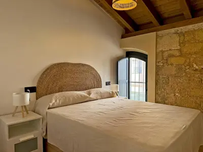 a bedroom with a large bed and a window at La Solera de Jerez - Ole Solutions in Jerez de la Frontera