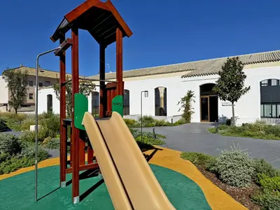 a playground with a slide in front of a building at La Solera de Jerez - Ole Solutions in Jerez de la Frontera