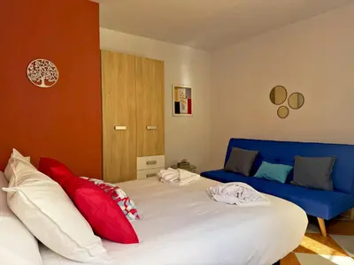 a bedroom with a large bed with red and blue pillows at Casa Luz de Azahar - Ole Solutions in Jerez de la Frontera