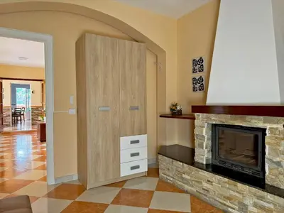 a living room with a fireplace and a wooden cabinet at Casa Luz de Azahar - Ole Solutions in Jerez de la Frontera