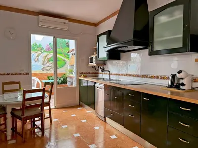 a kitchen with green cabinets and a table with a dining room at Casa Luz de Azahar - Ole Solutions in Jerez de la Frontera