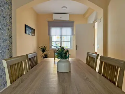 a dining room table with a vase on top of it at Casa Luz de Azahar - Ole Solutions in Jerez de la Frontera
