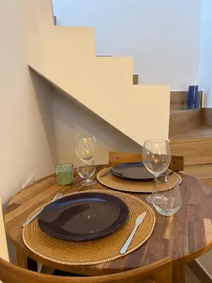 a wooden table with two plates and glasses on it at Apartamento TATA, Arcos de la Frontera in Arcos de la Frontera