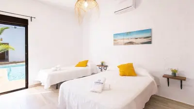 two beds in a room with a pool at Galdana Chiclana de la Frontera by Ruralidays in Chiclana de la Frontera