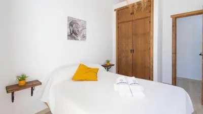 a bedroom with a white bed with two slippers on it at Galdana Chiclana de la Frontera by Ruralidays in Chiclana de la Frontera