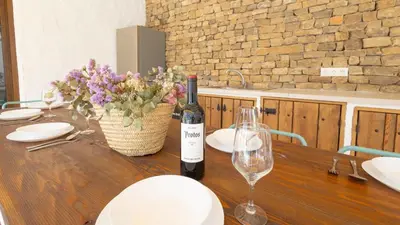 a bottle of wine sitting on a wooden table with glasses at Galdana Chiclana de la Frontera by Ruralidays in Chiclana de la Frontera