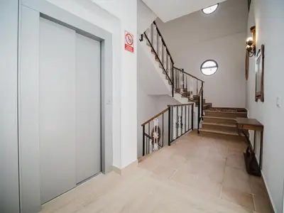 a hallway with stairs and a sliding glass door at Casa Rural El Charruado in Sanlúcar de Barrameda