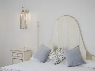 a bedroom with a white bed with blue pillows at Casa Rural El Charruado in Sanlúcar de Barrameda