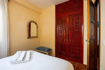 a bedroom with a red door and a white bed at Bahia Beachfront Apartment in El Puerto de Santa María