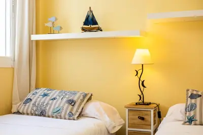 a bedroom with a bed and a shelf on the wall at Bahia Beachfront Apartment in El Puerto de Santa María