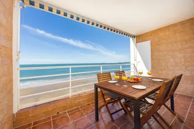 a dining room with a table and a view of the ocean at Bahia Beachfront Apartment in El Puerto de Santa María