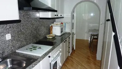 a kitchen with a sink and a microwave at Dúplex a 700 m de la Playa de La Barrosa in Novo Sancti Petri