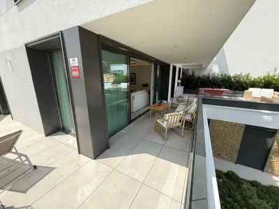 a patio with chairs and tables on a building at Apartamento RG Acciona Vistahermosa in El Puerto de Santa María
