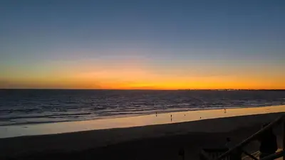 a sunset on the beach with the ocean at Apartamento RG Acciona Vistahermosa in El Puerto de Santa María