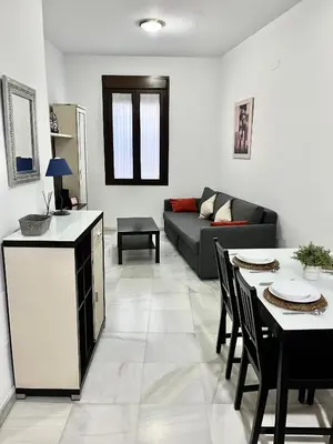 a living room with a couch and a table at La Bodega Suite - Parking gratis in Jerez de la Frontera