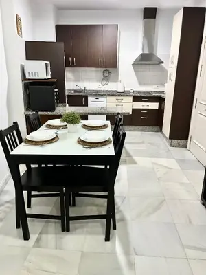 a kitchen with a table and chairs in it at La Bodega Suite - Parking gratis in Jerez de la Frontera