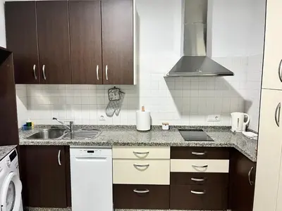 a kitchen with brown cabinets and a sink at La Bodega Suite - Parking gratis in Jerez de la Frontera