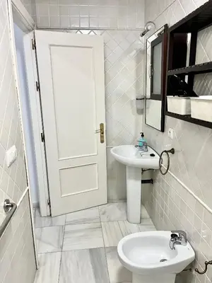 a white bathroom with a sink and a toilet at La Bodega Suite - Parking gratis in Jerez de la Frontera