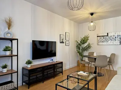 a living room with a tv and a table at Apartamento Renfurbis - Ole Solutions in Jerez de la Frontera