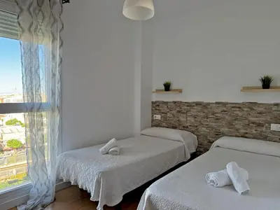 a room with three beds and a window at Apartamento Renfurbis - Ole Solutions in Jerez de la Frontera