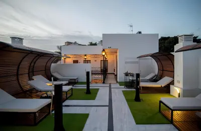 a balcony with chairs and tables on a building at AT La Maquinilla in Jerez de la Frontera