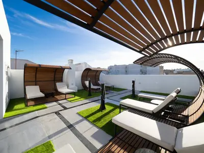 a rooftop patio with chairs and tables on a roof at AT La Maquinilla in Jerez de la Frontera