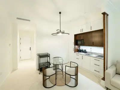 a kitchen and dining room with a glass table and chairs at AT La Maquinilla in Jerez de la Frontera