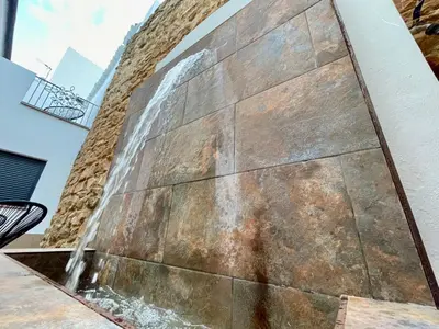 a water fountain on the side of a building at Mape Loft Rural Aljibe in Algar