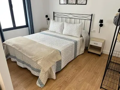 a bedroom with a bed and a wooden floor at La Gañanía in Jerez de la Frontera