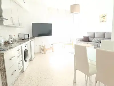 a white living room with a couch and a tv at piso LuMa in Jerez de la Frontera