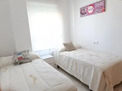 a bedroom with two beds and a window at piso LuMa in Jerez de la Frontera