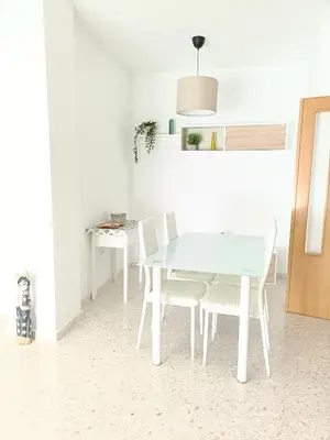 a white dining room with a white table and chairs at piso LuMa in Jerez de la Frontera
