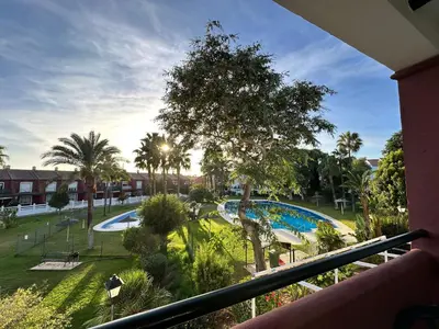 a view of a pool from a balcony of a resort at Apartamento La Barrosa - Aldea del Coto in Novo Sancti Petri