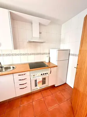a kitchen with a white refrigerator and a sink at Apartamento La Barrosa - Aldea del Coto in Novo Sancti Petri