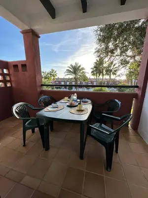 a table and chairs on a patio with a view at Apartamento La Barrosa - Aldea del Coto in Novo Sancti Petri