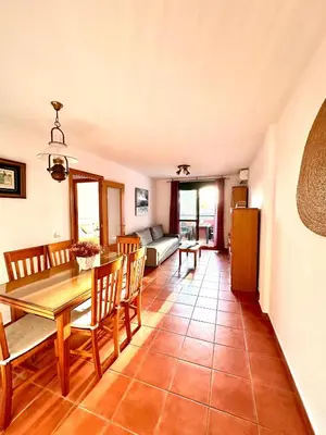 a dining room and living room with a table and chairs at Apartamento La Barrosa - Aldea del Coto in Novo Sancti Petri
