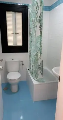 a bathroom with a toilet and a shower curtain at Martiniano in Conil de la Frontera