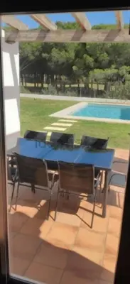 a blue table and chairs on a patio with a pool at Martiniano in Conil de la Frontera