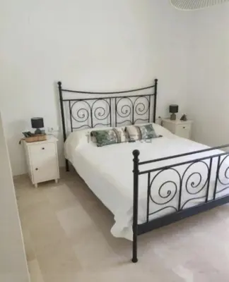 a bedroom with a large bed and a night stand at Martiniano in Conil de la Frontera