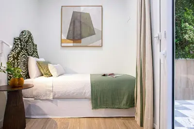 a bedroom with a bed with a green blanket at Genteel Home Patrocinio Cádiz in Cádiz