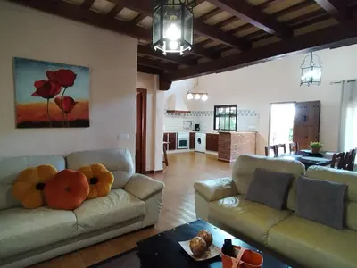 a living room with two couches and a kitchen at Casa Sebas in Conil de la Frontera