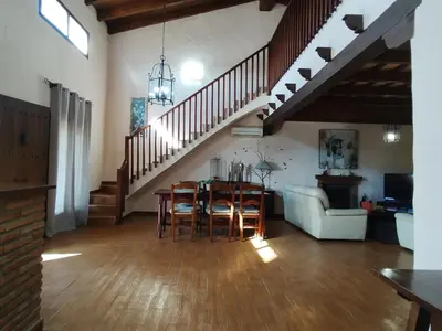 a living room with a table and a staircase at Casa Sebas in Conil de la Frontera