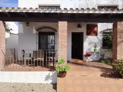 a house with a patio with chairs and a fence at Casa Sebas in Conil de la Frontera