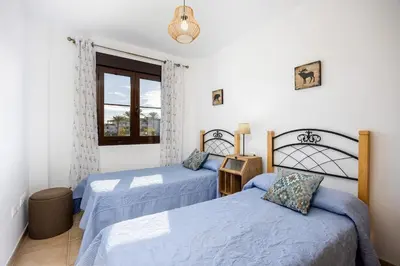 a bedroom with two beds and a window at Barrosa Beach Apartment - Chiclana de la Frontera in Novo Sancti Petri